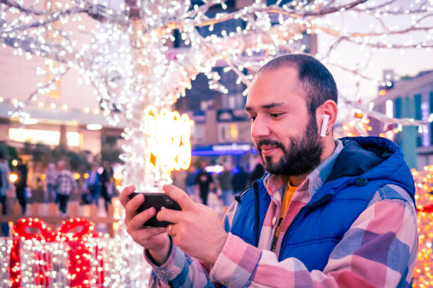 A man playing a game on his phone. stock photo