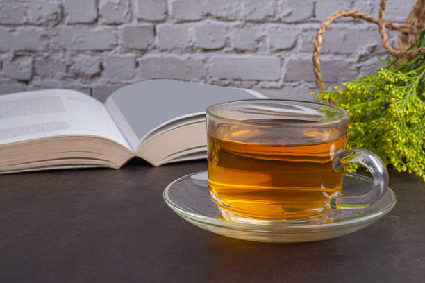 istock A teacup with flowers and a bookon a dark background with a white brick wall 1445115697