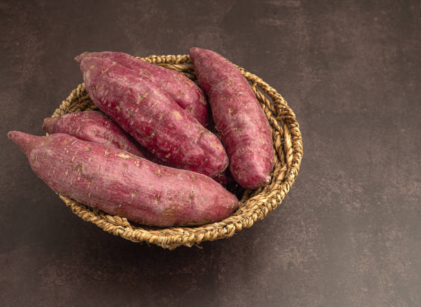 istock Purple yams pile on a basket on a brown background 1445116556