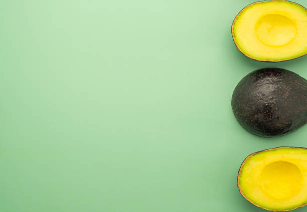 istock Top view of the fresh avocado half on a green background 1445116822