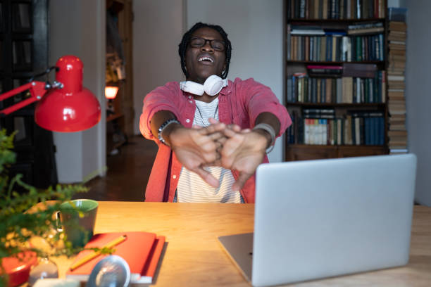 istock Sleepy African student guy yawning stretching arms while studying on laptop for long hours at home 1445117817