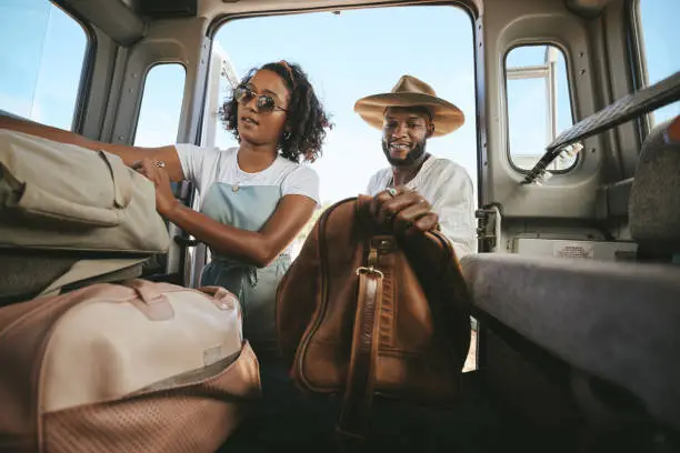 Photo of Black couple, travel and packing for road trip, journey or adventure with bags together. Happy African American man and woman pack for traveling in summer vacation, holiday or break in Mexico