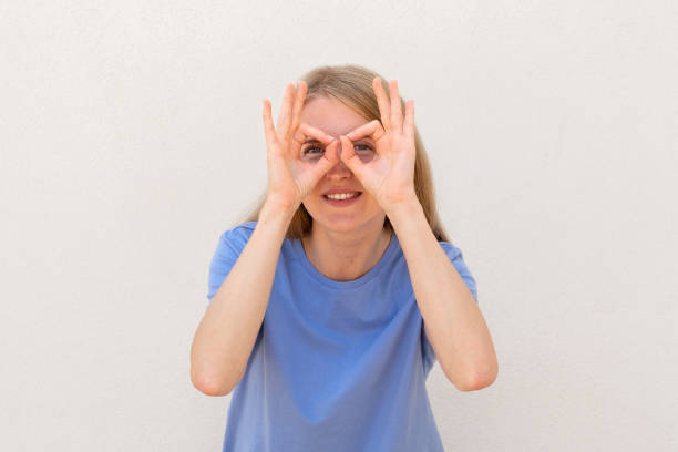 istock Cheerful young woman showing eyeglasses gesture 1445120109