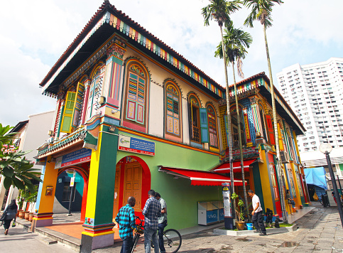 People beside by the Tan Teng Niah house Little India Singapore. Built in 1900 this is the only ancient Chinese building left in Little India and now a tourist attraction as it is colourfully painted.