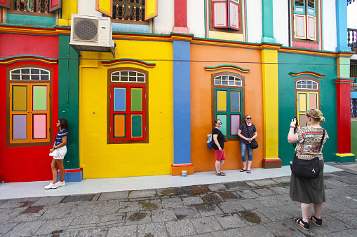 Tourists taking photos beside by the Tan Teng Niah house Little India Singapore. Built in 1900 this ancient Chinese building in Little India is now a tourist attraction as it is colourfully painted.