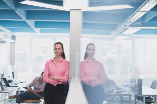 retrato da jovem mulher de negócios sorridente no escritório criativo da startup de coworking em espaço aberto. empresária de sucesso no cargo com copyspace. colegas de trabalho trabalhando em segundo plano. - real people young women women beautiful - fotografias e filmes do acervo