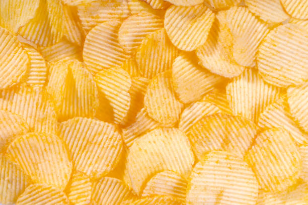istock Yellow crispy ridged potato chips close up. Food background 1445124595