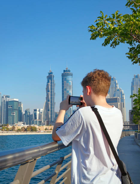 istock Boy taking photo of Dubai skyline 1445125071