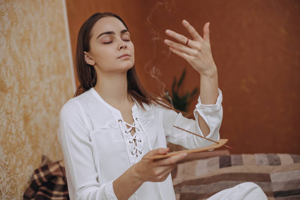 istock Female with closed eyes enjoying aromatherapy with incense stick 1445126946