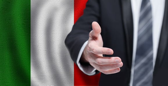 Italian business, politics, cooperation and travel concept. Hand on flag of Italy background.