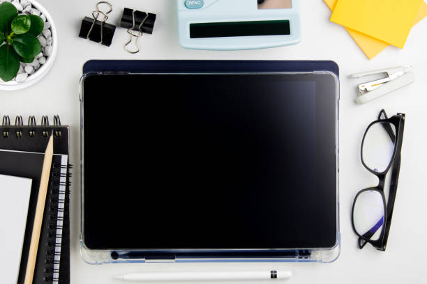 istock Top view modern white desk with tablet computer for graphic design, book pages and other accessories on  white background 1445128419