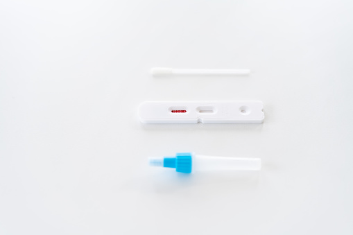 a rapid antigen test kit on white desk