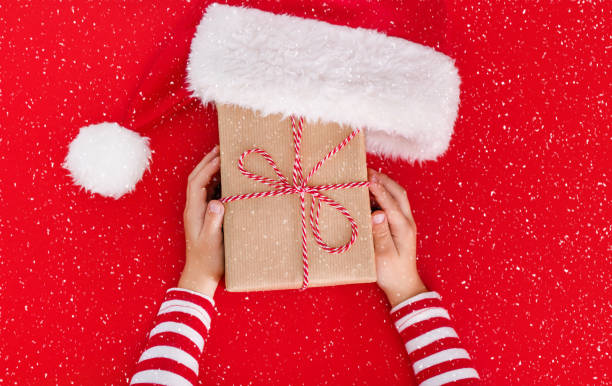 istock gift box in children's hands on a red background 1445131228