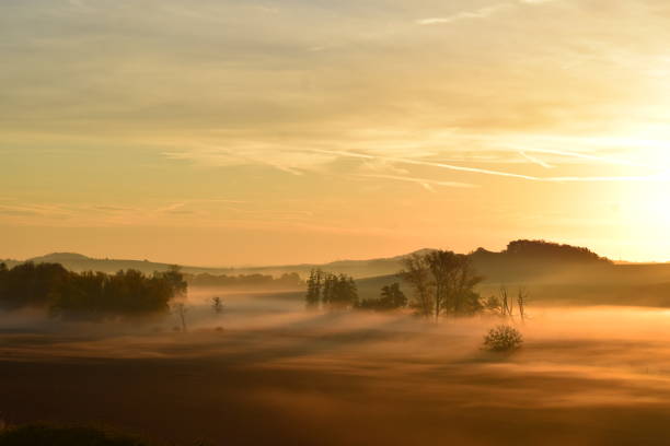 istock orange sunrise light on low fog 1445133363
