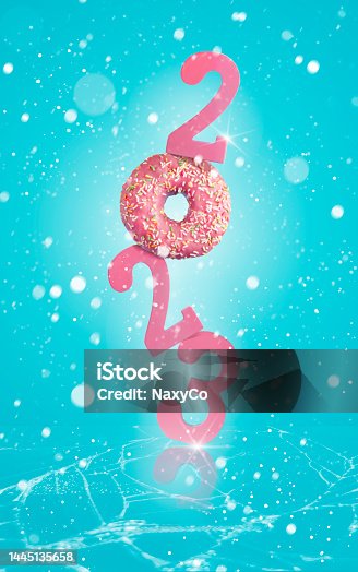 istock Vertical composition of year 2023 with doughnut instead of zero. Winter theme concept, snow falling around and cracked ice beneath the year. 1445135658