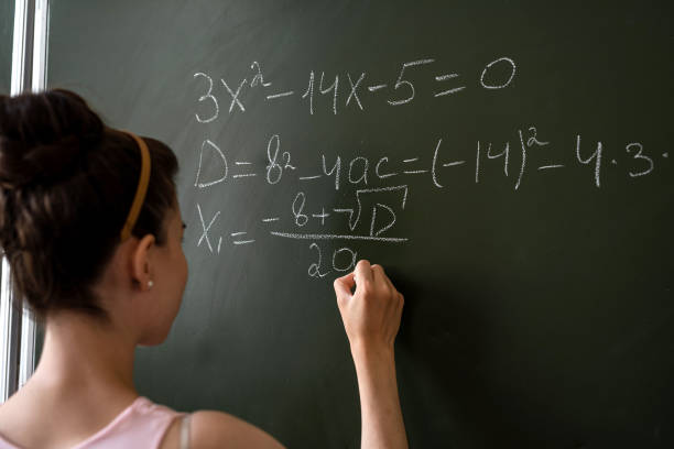 istock Clever female student writing on a chalkboard completing mathematical formulas 1445137761