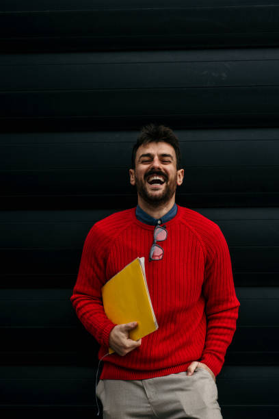 istock Smiling casual guy against the wall 1445142046
