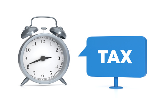 Tax written blue speech bubble and alarm clock. Time Concept.