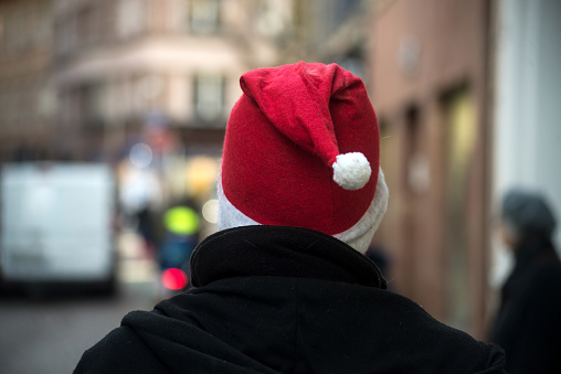 Portrait on back view of man wearing a christmas hat in the street
