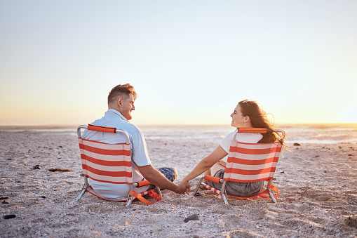 Love, relax and couple on the beach with hands holding for comfort, peace and wellness while on Toronto Canada vacation. Mockup, sunset and bonding man and woman enjoy romantic quality time together