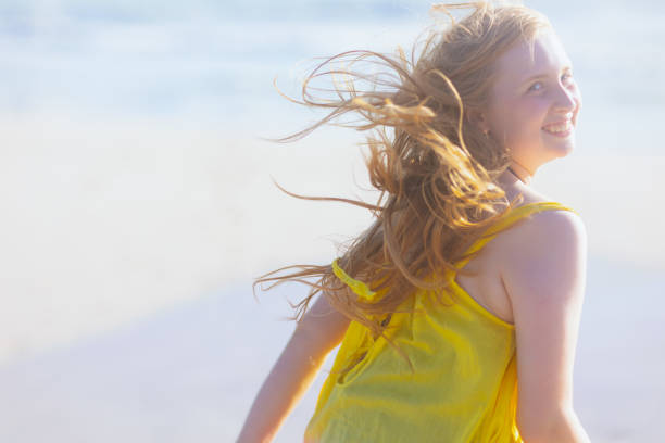 smiling modern teenager at the beach in colorful dress having fun time.