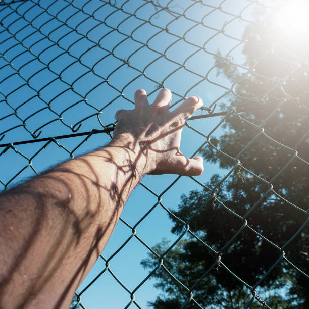 istock hand grabbing a metallic fence 1445148365