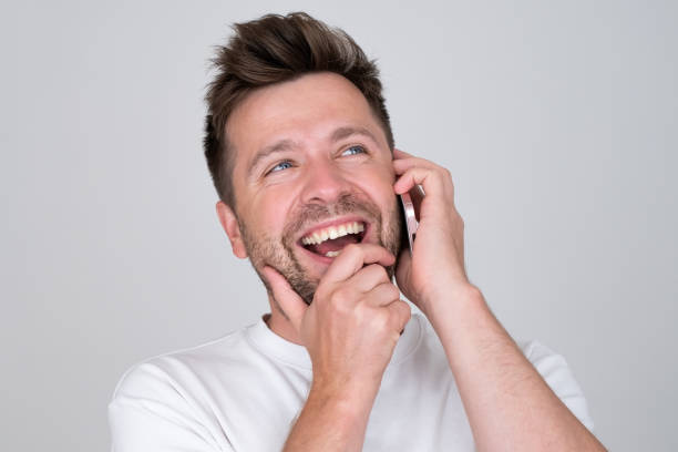 istock Young smiling happy caucasian man talking speaking by mobile cell phone. 1445149505