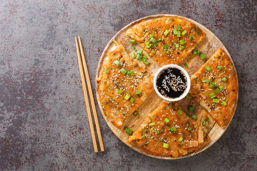 Kimchijeon Traditional Pancake From South Korea made from kimchi and green onion closeup on the wooden board on the table. Horizontal top view from above