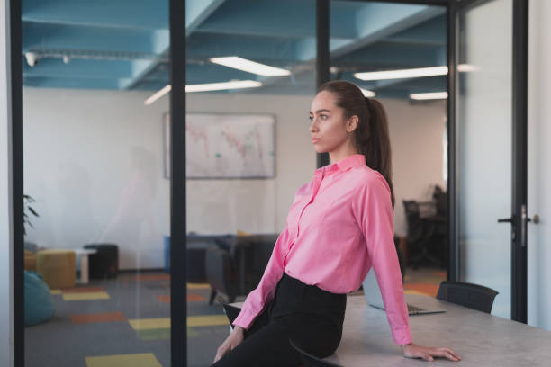 retrato da jovem mulher de negócios sorridente no escritório criativo da startup de coworking em espaço aberto. empresária de sucesso no cargo com copyspace. colegas de trabalho trabalhando em segundo plano. - real people young women women beautiful - fotografias e filmes do acervo