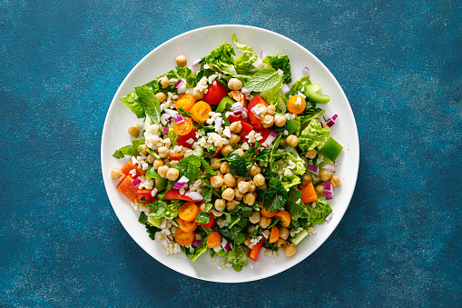 Tabbouleh salad. Tabouli salad with fresh parsley, onions, tomatoes, bulgur and chickpea. Healthy vegetarian food, diet. Top view