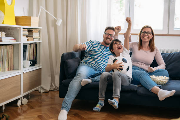 istock family watching soccer game at home 1445156357