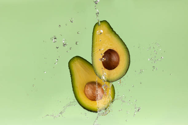 istock Fresh avocado on green background with water splash 1445156790