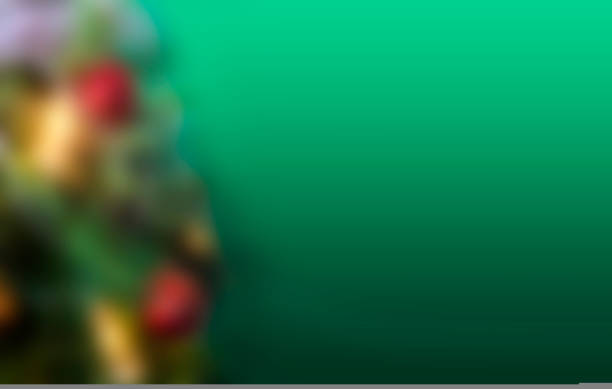 Christmas and New years eve blured green Background. Wide Angle Holiday Template with christmas toys, red and gold ball on fir tree and highlights. Panoramic Web banner with copy space for design.