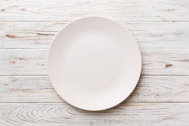 istock Top view of empty light plate on wooden background. Empty space for your design 1445158811