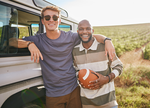 Sports, adventure and portrait of friends on road trip with black man holding football. Summer, nature and men with ball on vacation in countryside. Travel, games and happy people on outdoor holiday