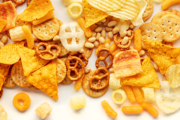 istock Salty snacks texture on white. Party food assorted mix. Potato chips etc 1445162539