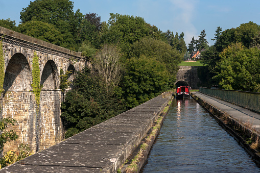 Chirk Aqueduct is part of Pontcysyllte Aqueduct and the Llangollen Canal World Heritage site, which stretches from Chirk to the Horseshoe Falls in Llangollen itself.  Completed in 1801 by William Jessop and Thomas Telford, the aqueduct is 710 foot (220 m) long and carries the canal 70 feet above the beautiful River Ceiriog across 10 circular masonry arches.  The slightly later Chirk Railway Viaduct runs parallel.