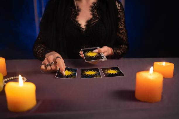istock Tarot reader picking tarot cards near burning candles.Candlelight in dark.Tarot reader or fortune teller reading and forecasting 1445165619