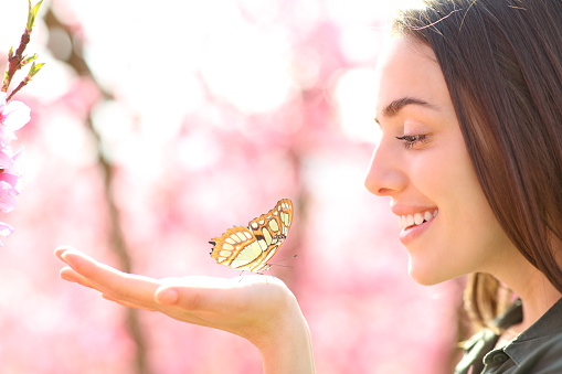 Happy woman with a butterfly in the hand