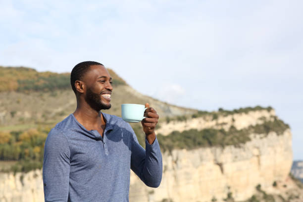 istock Happy black man drinking coffee contemplating 1445165952