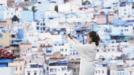 istock Asian Chinese female tourist photographing with smart phone at Chefchaouen townscape 1445166160