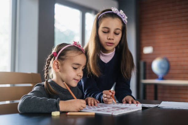istock Girl helping her sister doing her homework 1445166194