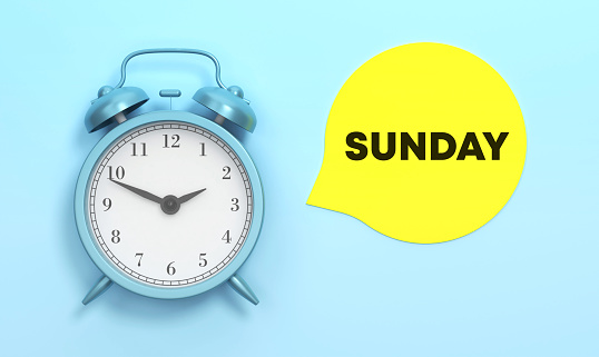 Sunday written Yellow speech bubble and Blue Alarm Clock On The Blue Background. Time Concept.