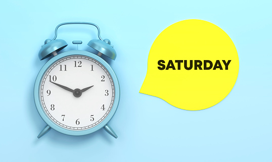 Saturday written Yellow speech bubble and Blue Alarm Clock On The Blue Background. Time Concept.