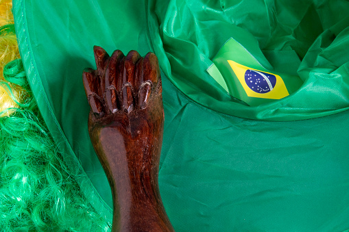 flag of Brazil in a wave filling the frame and a green and yellow wig