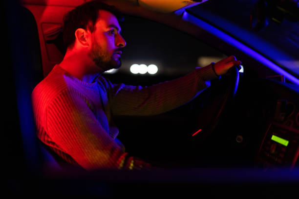 istock Young Man Driving His Car At Night 1445171850