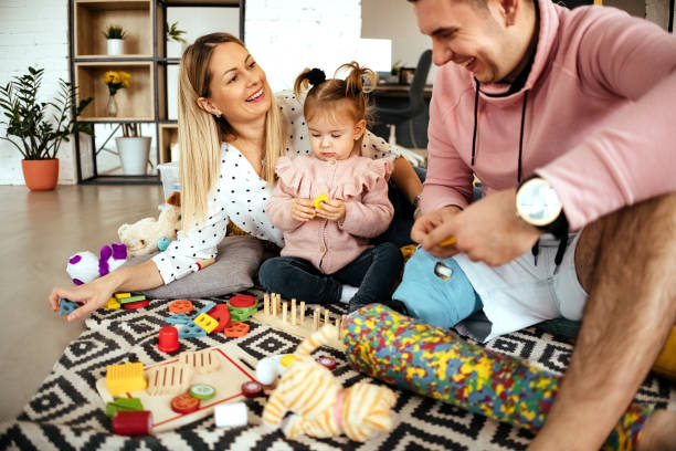 istock Happy young parents playing toys with small daughter 1445173093