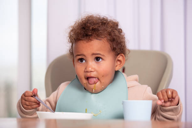 istock Baby girl eating from a plate. 1445175041