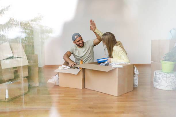 istock Couple giving each other high five while unpacking up boxes in new apartment 1445178766