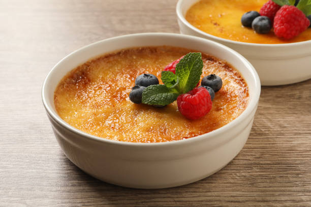 istock Delicious creme brulee with fresh berries on wooden table 1445181605